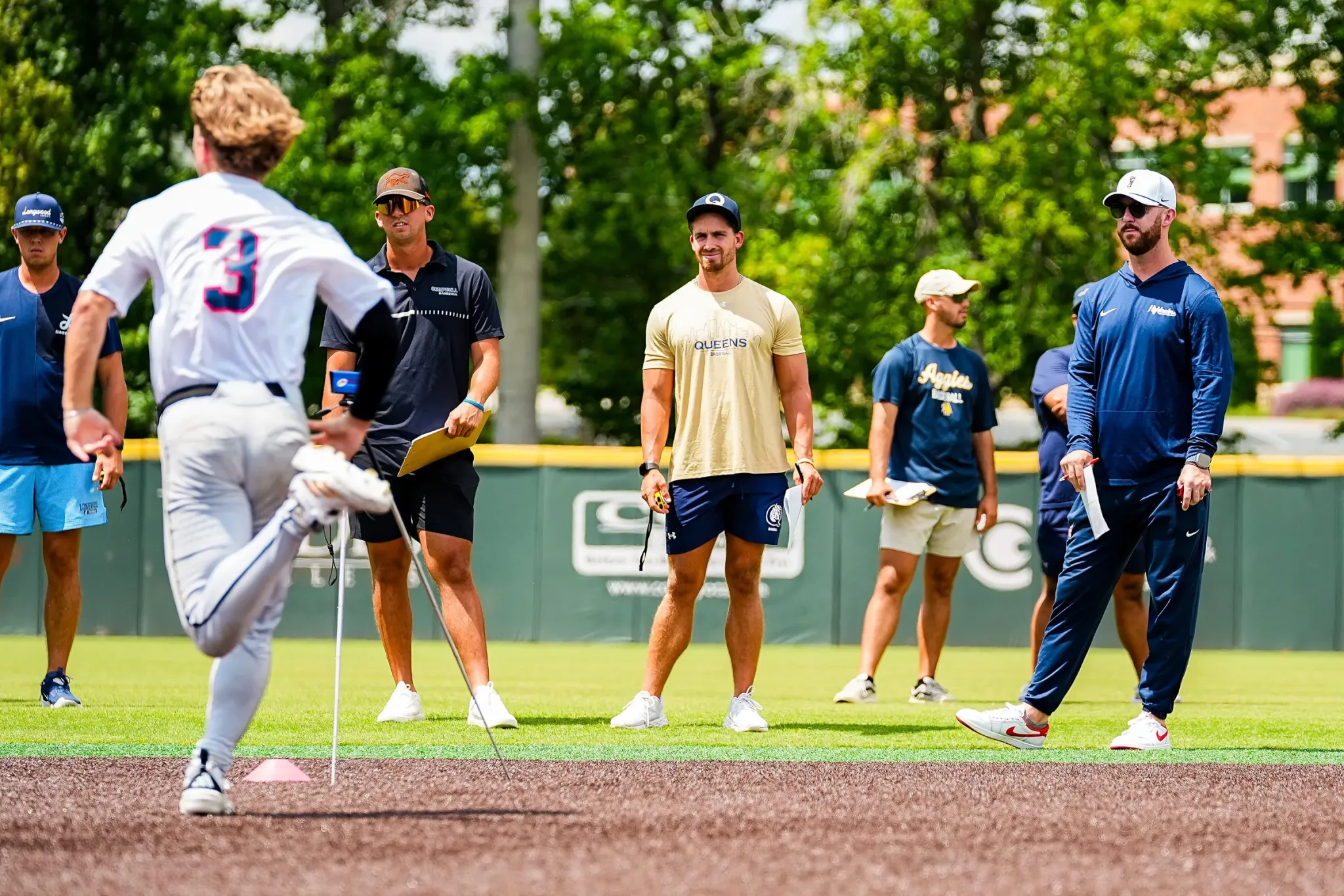 Coach working with players on the field at the Carolina Classic
